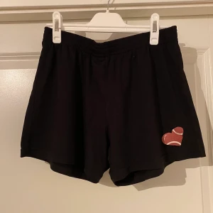 Svarta träningsshorts  - Svarta träningsshorts med ett baseball-hjärta. Oanvända.  Finns i Västerås, annars står köparen för frakt.