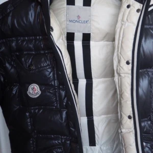 Moncler jacka - Moncler quincy jacket. Svart. Dam modell. Kan diskutera pris då den varit med några vintrar. Kontakta för fler bilder. Kan mötas upp i Stockholm. Den har en slitning som är igensydd på vänstra överärmen. Den syns inte särskillt mycket. Annars är jackan i väldigt gott skick. Den finns en luva men den är justerbar. Man kan knäppa av och knäppa på den. ( jackan är äkta ) HÖGSTA BUD: 1460kr