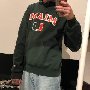 Champion hoodie - En mörkgrön Champion hoodie med universitetstryck. Väldigt mysig passform