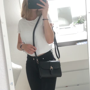 Svart axelväska - svart axelväska med justerbara band och guldiga detaljer. i princip oanvänd och i bra skick! fler bilder finns❤️ finns möjlighet till spårbar frakt - 63 kr