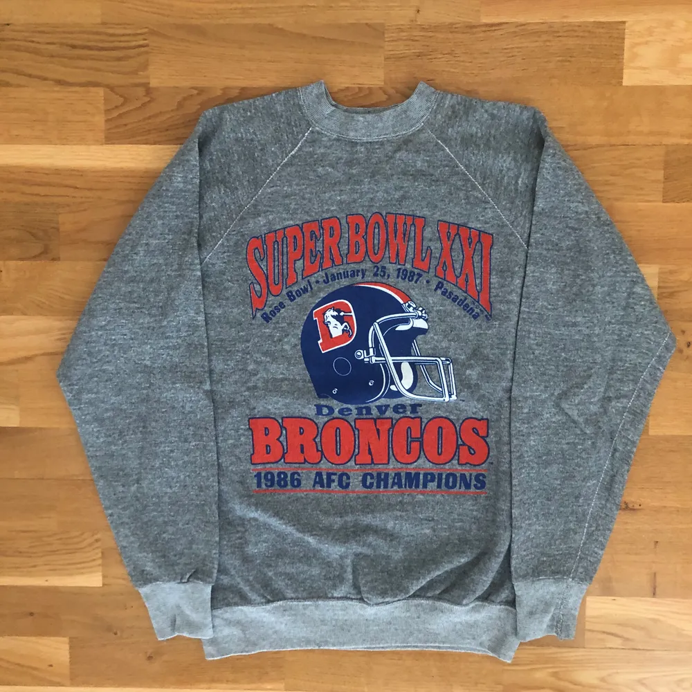 Säljer denna riktigt coola vintage tröjan från Denver Broncos vinst i superbowl 1986. Tröjan är gjord i USA och är från 1986. Tröjan är storlek M men skulle snarare säga att den passar Xs. Tröjan är i grymt skick för sin ålder, dock finns det två fläckar (kan skicka bild om det önskas) och därav det väldigt låga priset. Har även en t-shirt från samma år och vinst, så om du vill ha båda kan vi fixa ett najs paketpris. Det är bara att skriva om du undrar något, läs gärna bio innan! 🌎✌🏻🧡. Tröjor & Koftor.