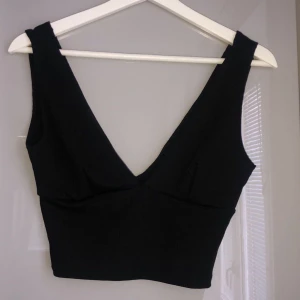 Svart topp  - Svart urringad & croppad topp. Samma urringning fram som bak. Storlek XS/S. Frakt tillkommer.