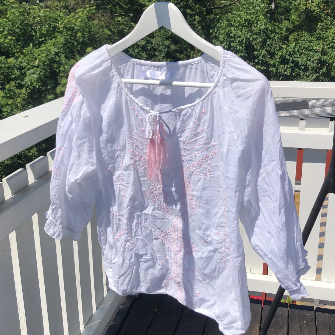 Vit blus med rosa brodyr