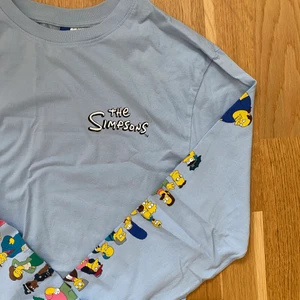 simpsons-tröja - ljusblå simpsons longsleeve med karaktärerna tryckta längsmed armarna. nyskick. h&m’s killstorlek XS, sitter lite oversize på mig som brukar ha damstorlek S