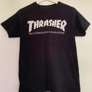Svart Thrasher T-shirt med vit text i storlek S. Använd men i väldigt fint skick. Köpt för 450kr, Säljer för 150kr+frakt.