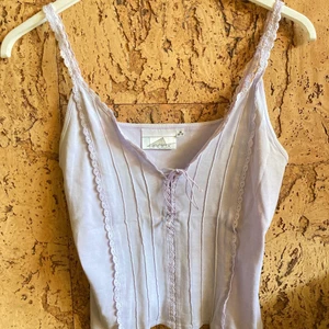 Lavendellila 70-tals linne - Gulligt linne från 70-talet med snörning, äkta retro! 🥰 Ganska kort, nästan crop-at 🔥 Fint skick, men en liten brun fläck som knappt syns (se bild 3). 🌟 Frakt betalas av köparen, kontakta mig vid frågor/fler bilder!