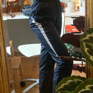 Byxor - Jättecoola blåa byxor med en vid rand på dem. Byxorna är i trängsmatrial och har dragkedjor vid fickorna. Säljer eftersom jag inte har någon användning för dem längre. Frakt tillkommer ✨🧚🍄