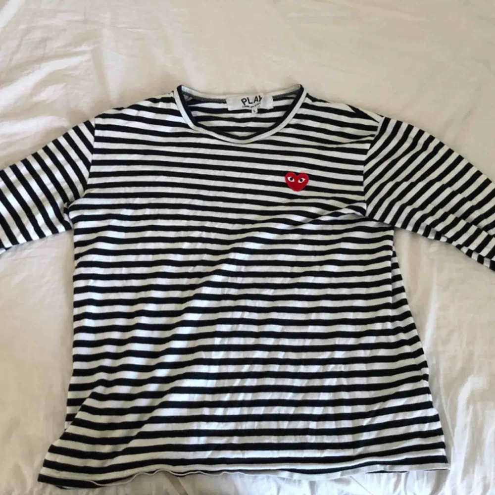 CDG långärmad tröja i svart och vitt inte mycket använd men har ett litet hål på ryggen (se bild 3) men kan sy ihop det till den som köper :) . Toppar.