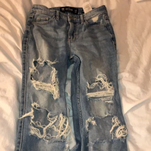 Hollister jeans - Hollister jeans, sitter inte så tajt för att vara skinny jeans. är typ ankle jeans. Nästan alla hålens trådar är trasiga därför är det billigt pris :D asså priset kan diskuteras vet inte riktigt vad jag ska sätta