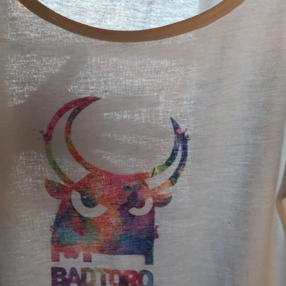 Vit t-shirt med tryck från badtoro. Genomskinlig. Storlek xs. T-shirts.