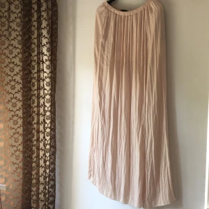Långkjol från Zara - Nude/ljusrosa långkjol från Zara Trf. Siden-aktigt material och resår i midjan. Lång slits och med kort underkjol i trikå. Storlek S. Fint skick. Köparen står för frakt!