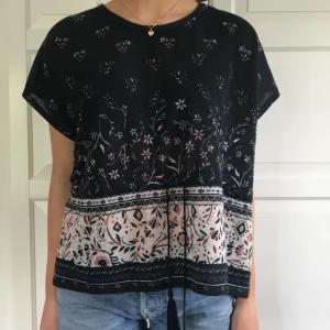 Topp - Topp i bohemisk stil. Marinblå med mönster. Toppen har dragsko i midjan samt slit på sidan. Helt oanvänd.