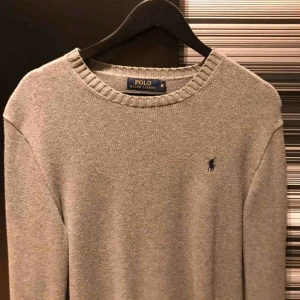  - Jättefin grå stickad tröja från Ralph Lauren med svart logga på. Den är i M men är lite stor o storleken så den funkar perfekt på en i L. Frakt ingår. Originalpriset låg på ca 1000-1200 så detta är ett riktigt kap. Har själv knappt använt den
