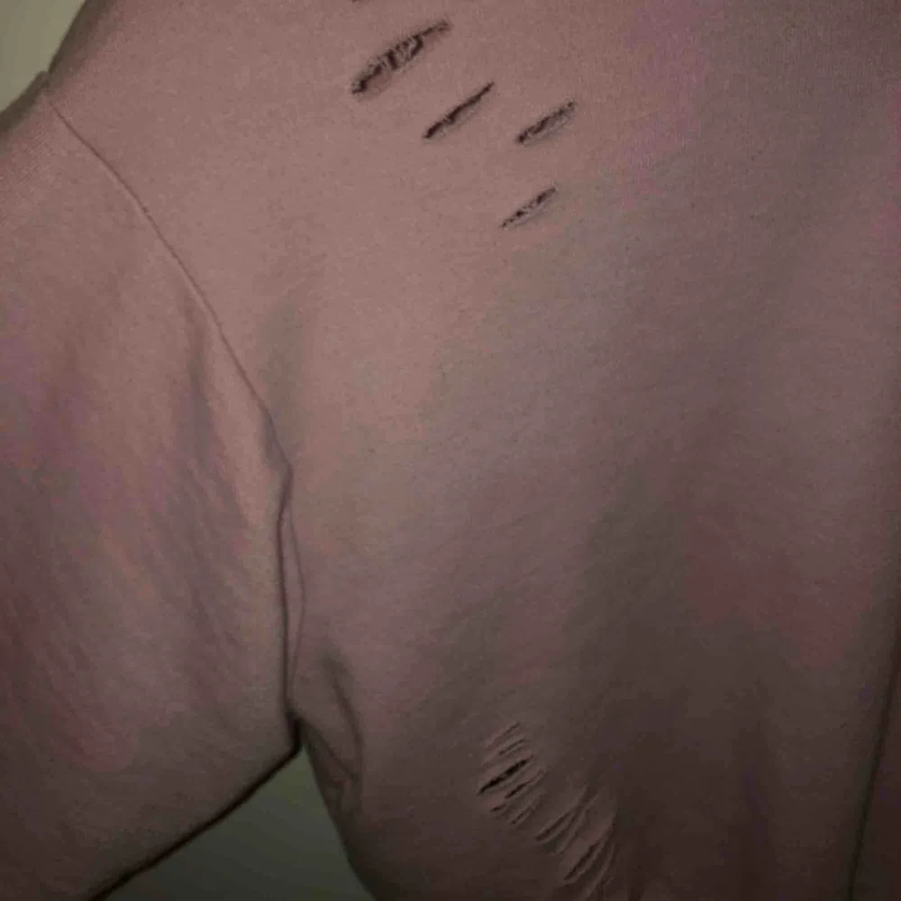Rosa croppad sweatshirt från Bershka. Tröjan är oversized. Den har även tillgjorda hål lite överallt i tröjan vilket är en snygg detalj. Säljes pga att jag ej har användning för den. . Toppar.