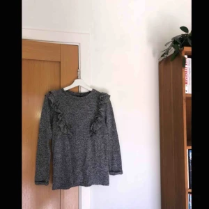  - Grå långärmad tröja med volanger, storlek S. 