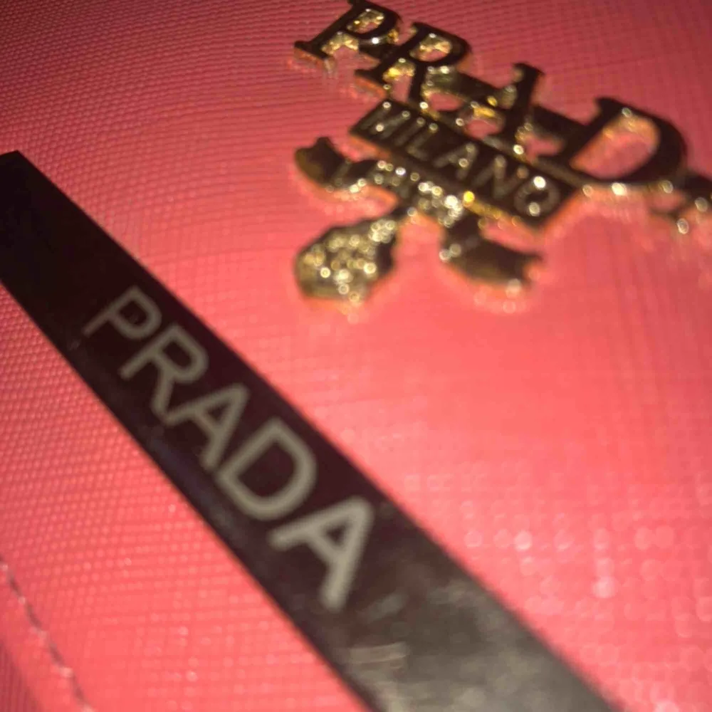 En fejk Prada plånbok med mycket utrymme och plats för både kort och kontanter mm. Aldrig använd. Aprikos/Rosa färg. . Accessoarer.