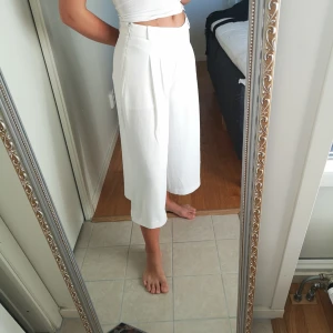  - Croppade vita byxor, innebyxor högst upp så ej genomskinliga. Sömmen har släppt lite vid ena benet (därav priset), enkelt fixat med lite tråd och nål! 