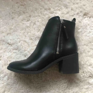  - Nytt skick! Svart känga med klack och öppningsbar dragkedja. 