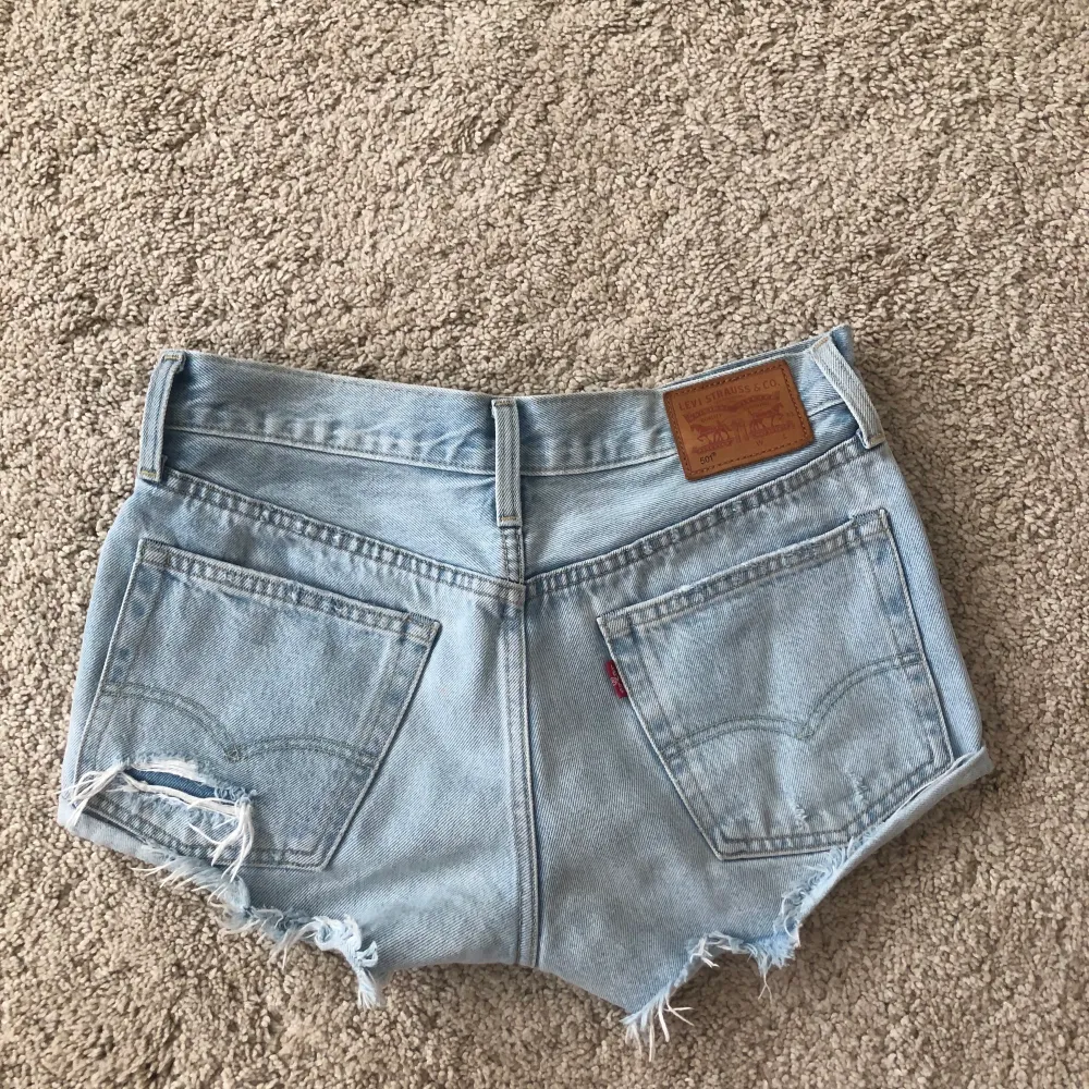 Super fina Levis jeansshorts i ljus tvätt med snygga slitningar. Perfekt nu till sommaren! W26 Köparen står för frakten (63 kr). Shorts.