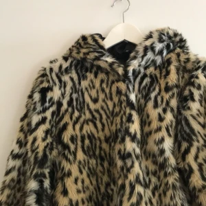 Fuskpäls - Världens bästa leojacka!! Fuskpäls som slutar i midjan, luva bak! Storlek 42 men skulle säga att den är mer som en 38! Frakt ingår 🍀