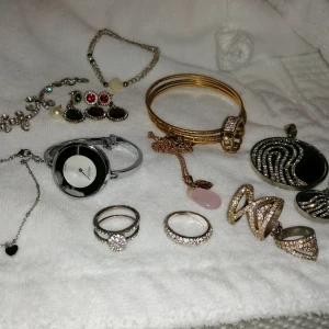 Diverse smycken - Diverse smycken i befintlig skick som på bilden, bland annat halsband, fotlänk, armband, ringar, örhängen och klocka. Klockan har jag inte använt på länge därav igen garanti på att den funkar men vet att den behöver byta batteri. (frakt 42kr) 