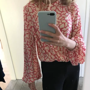 Blus i rosa leopardmönster - Fin blus med ballongärm i leopardmönster (vit och rosa) från Lindex. Endast använd 2 gånger, så i mycket bra skick. Den är i strl S men skulle säga att den är stor i storlken vilket gör att den passar M också!