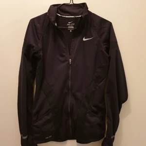 Nike Löparjacka - Svart jacka från Nike för träning utomhus. Fodrad och med windstopper -> Passar kyliga dagar. Två fickor fram och en bak med dragkedja. Reflexdetaljer. Frakt ingår ej, kan hämtas i hägersten/Södermalm. Nypris ca 1200.- knappt använd.