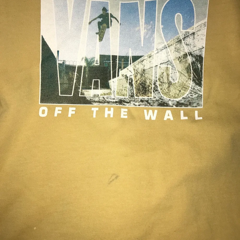 En gul tshirt från vans. En liten fläck under loggan samt två små repor nära nedre tröjlkanten. T-shirts.