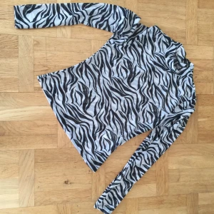 Transparent zebratopp - Snygg topp i halvt genomskinligt tyg med högre krage och zebramönster. Aldrig använd 