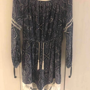  - Fin blå-mönstrad jumpsuit med spets detaljer vid benen från Nelly, storlek L men passa även M och XL. Använd få gånger.  Nypris: 400kr köparen står för frakt!