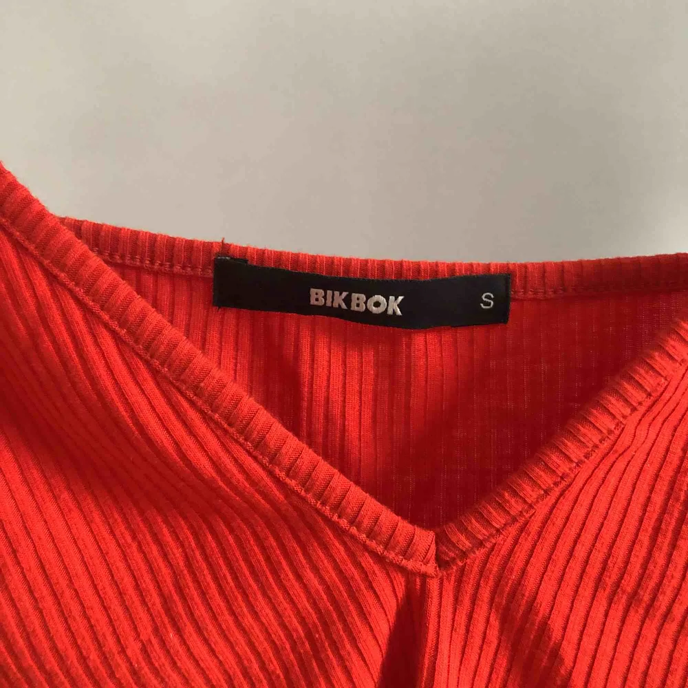 Rött linne från BikBok, ganska urringat men perfekt när det blir varmare väder! Sällan använt i gott skick! Eventuell frakt står köparen för ✨🌿🌼💕. Toppar.