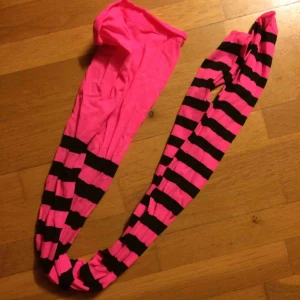  - Neonrosa strumpbyxor med svarta streck. Frakt: 42 kr