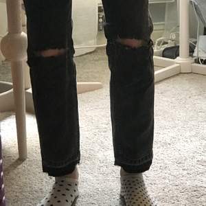 Ett par svara raka jeans från zara med hål på knäna. De är nerlagda och är k storlek 32 men jag skulle säga att dom sitter bra som storlek 34.