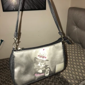 Söt väska💓 - Säljer den här gulliga baguetteväskan💕👜 Man ka ha den på två sidor, antingen den med tryck eller ha den på den svarta glittriga sidan✨ Frakten kostar 45kr. Kan gå ner i pris vid snabb affär