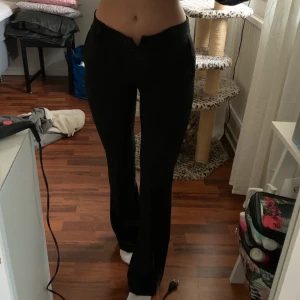 Utsvängda kostymbyxor - Jättesnygga lågmidjade kostymbyxor från DesignbySi som tyvärr inte går att knäppa i midjan på mig som vanligtvis har XS. De är små i storleken! Byxorna är bra i längen för mig som är ungefär 160 cm. Helt nya så endast testad under dessa bilder. Frakt tillkommer på 42kr! 