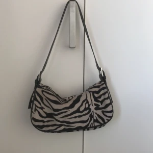 Väska med Zebramönster - Jättefin och trendig väska med zebramönster! Säljer för att den inte används längre. Från Ginatricot, Köpare står för frakt.