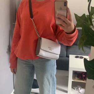 Guess väska - Vit och grå guess väska med fina detaljer, extra hål är gjorda i bandet så man kan justera det. Använd fåtal gånger