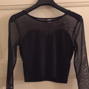 - Svart crop top med transparant tyg på armarna och halva ryggen. Från H&M, divided. 

Fint skick, använd ett fåtal gånger.