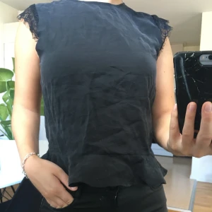 ZARA - Snygg oanvänd topp från Zara i storlek xs. Svart med spetsdetaljer vid axlar och på ryggen där toppen har en öppning. Oanvänd med prislapp kvar. Nypris 269kr (26euro). Mitt pris 100kr. Kan mötas upp i Skövde eller Hjo. Skickas mot fraktkostnad.