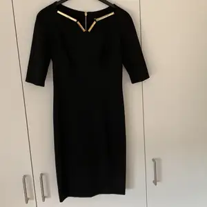 Underbar svart klänning i stretch kvalite med guld detaljer. Köpt i Rom. Använt ca. 2 gånger.
