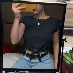 Croppad t-shirt - T-shirt med knytdetalj över magen som går att justera. Möts upp i sthlm eller köparen betalar för frakt! 😁 (ser ut att vara en fläck men det är bara på spegeln)