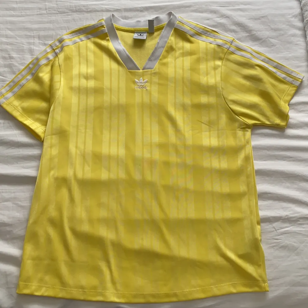En lite snyggare gul adidas t-shirt med vita detaljer i 100% polyester! Storlek S men passar oxå M då den är lite oversized. 200kr inkl frakt🥰 buda i kommnterarena eller skicka privat🌟. T-shirts.