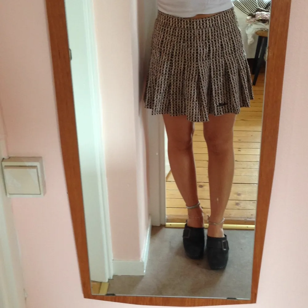 Vintage-kjol i brun-svart-vittmönster. Knappen där bak är borta men dragkedjan fungerar. Lite 