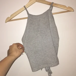  - Grå cropad topp från na-kd med snörning bak i ryggen med långa snören! passar även S då den bara är att knyta tightare. frakt tillkommer 💕