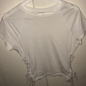  - Vit t-shirt med snörning , jättefin! Men kommer aldrig till användning 