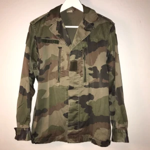  - Oversize camouflage jacka med dold knappning, två fickor med dragkedja.  Alternativ kragknäppning - se bild.  Använd endast ett fåtal gånger - Fint skick! 