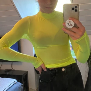 Neongul tröja - En neongul tröja i tunt material som nät. Storlek XS från H&M men som är väldigt stretchig. 