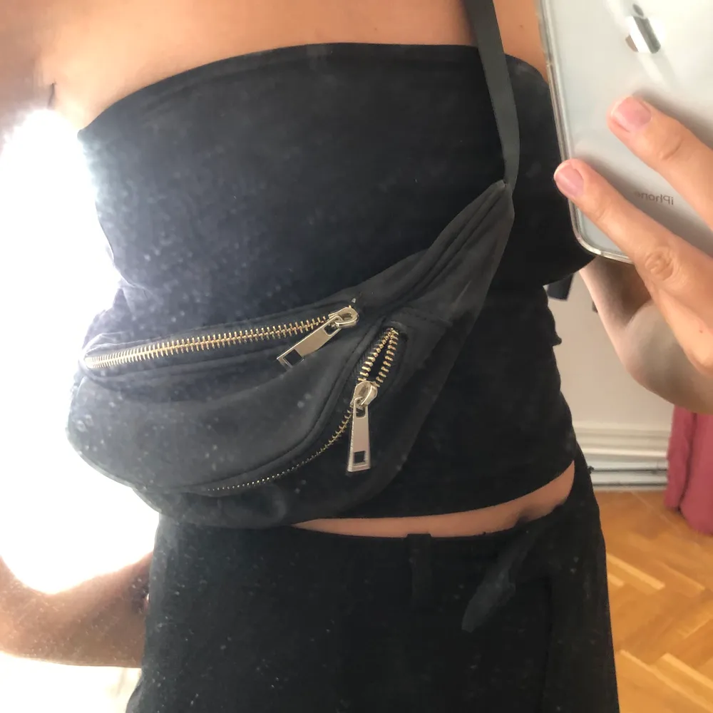 Svart crossbody/fannypack väska från ASOS med guldiga dragkedjor. Spänne finns och går att göra banden kortare eller längre💜. Väskor.