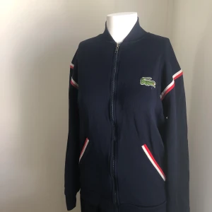 Lacoste vintage - Mörkblå träningsjacka från Lacoste. Passar S/M. Fått i arv. I mycket gott skick.