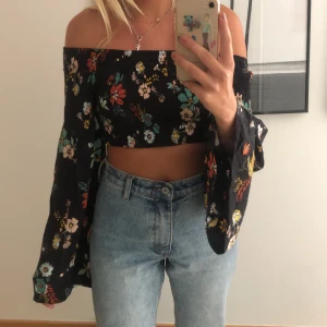 Jättefin blommig blus - Croppad, blommig, off shoulder blus använd en gång på födelsedagskalas. Fina utsvängda armar som är bra längd!